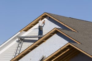 Workers installing siding on a home